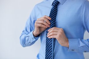 man adjusting his tie